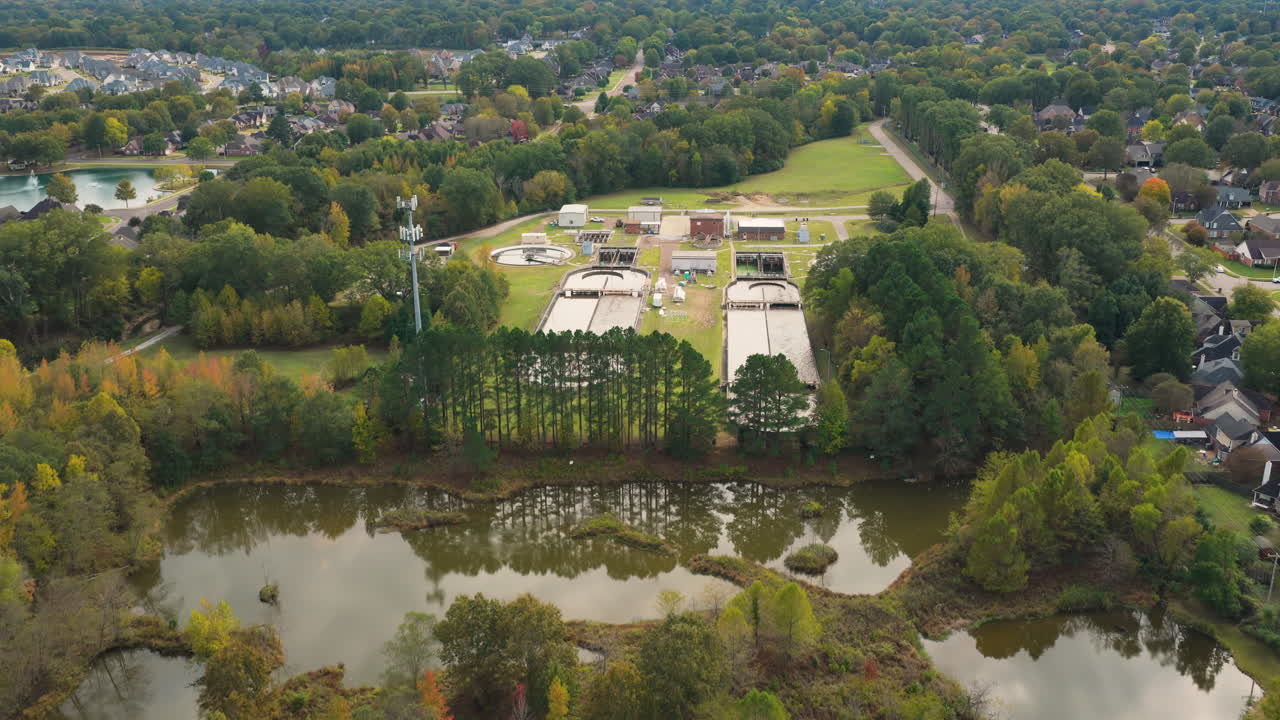 Efterårsskovens løvtag omkring et forstadskvarter i Collierville, Tennessee, USA, med et centralt placeret vandrensningsanlæg.