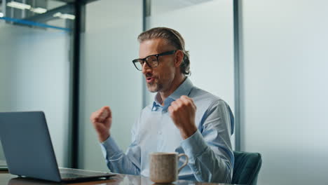 Glad-man-celebrating-success-at-workplace-close-up.-Joyful-businessman-rejoicing