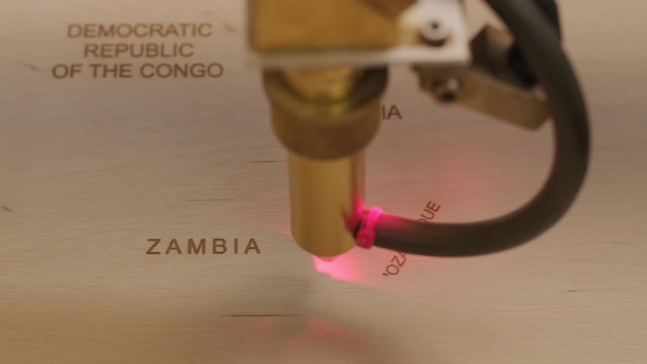 Cnc laser cutting machine cuts world map on wooden plank and plywood