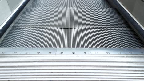 a close up view of old escalator outside of shopping mall going down