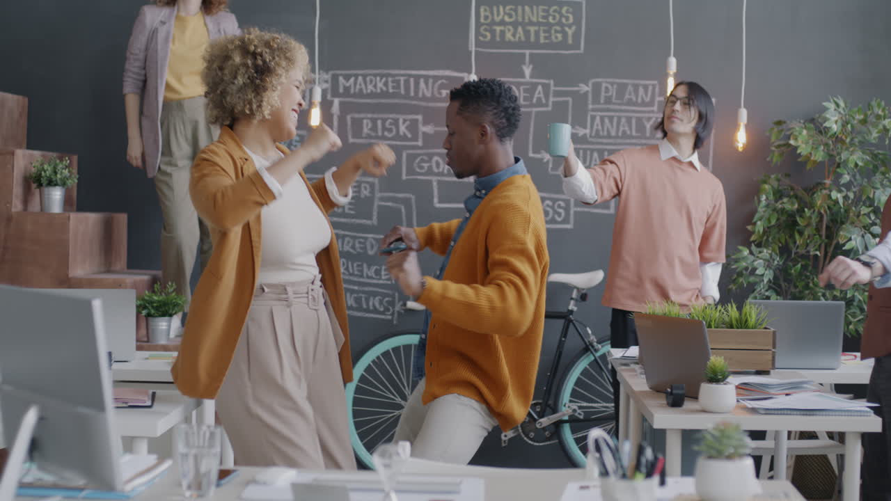 Happy and Energetic Employees Dancing in the Office