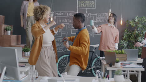 happy and energetic employees dancing in the office