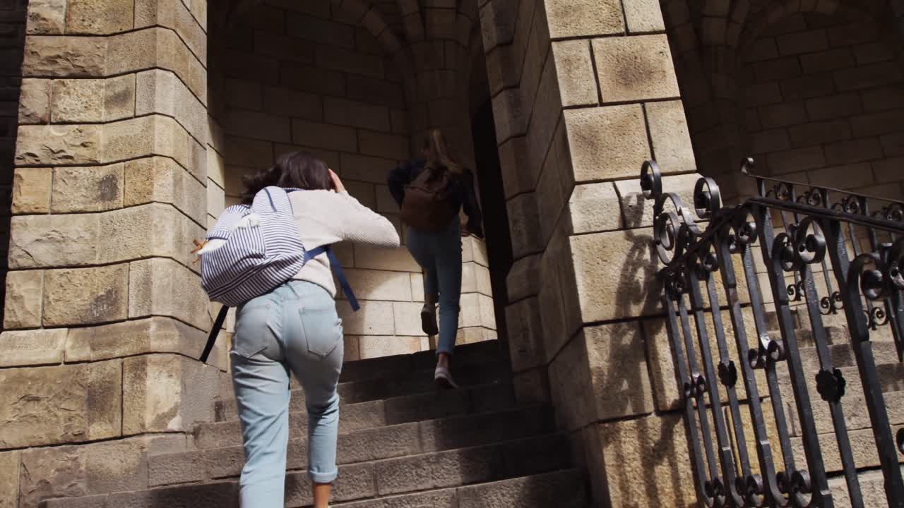 Vista posteriore di una ragazza caucasica e di una ragazza di etnia mista che si godono l'aria aperta.