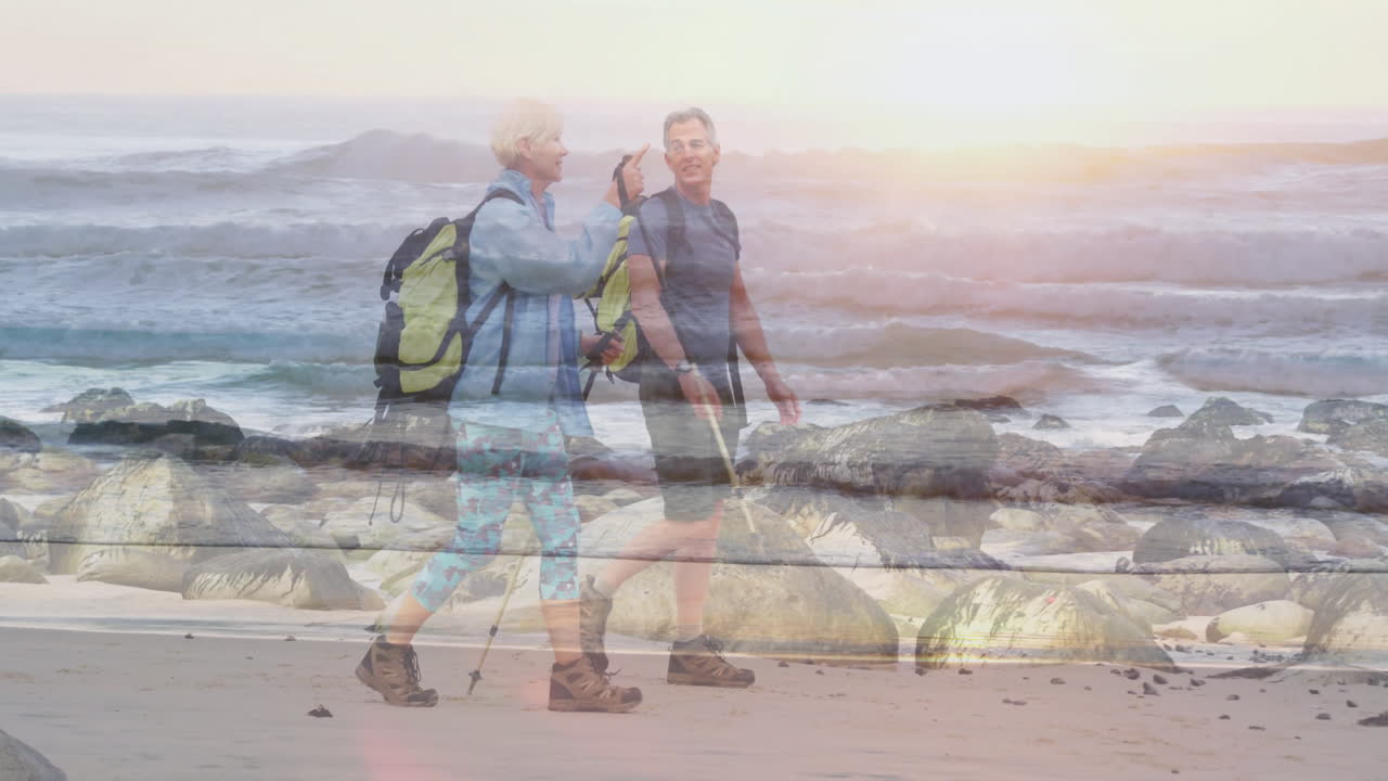 Couple walking rocky beach during sunrise, with animated health chart and heart icon