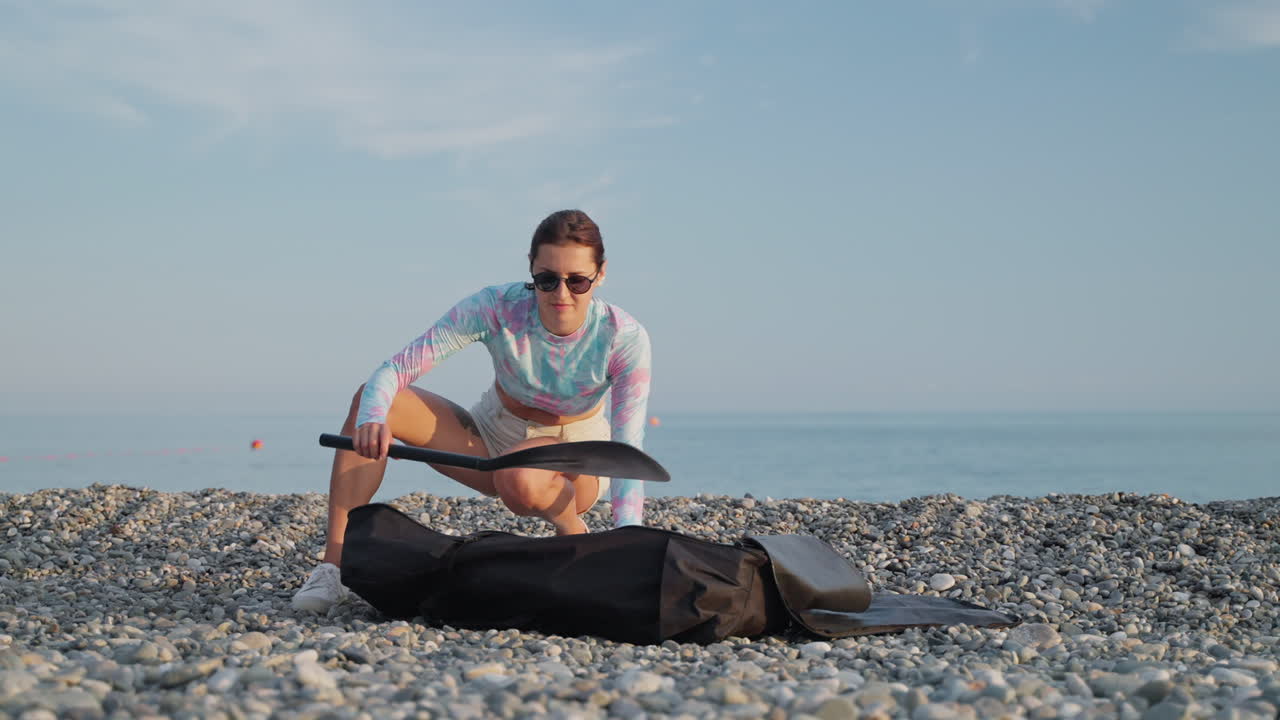 mujer empacando una bolsa de playa en la playa