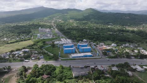 aerial view of traffic on highway in front of prison and green mountains in background