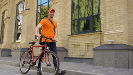 man walking with bike on city street. courier working for food delivery service.