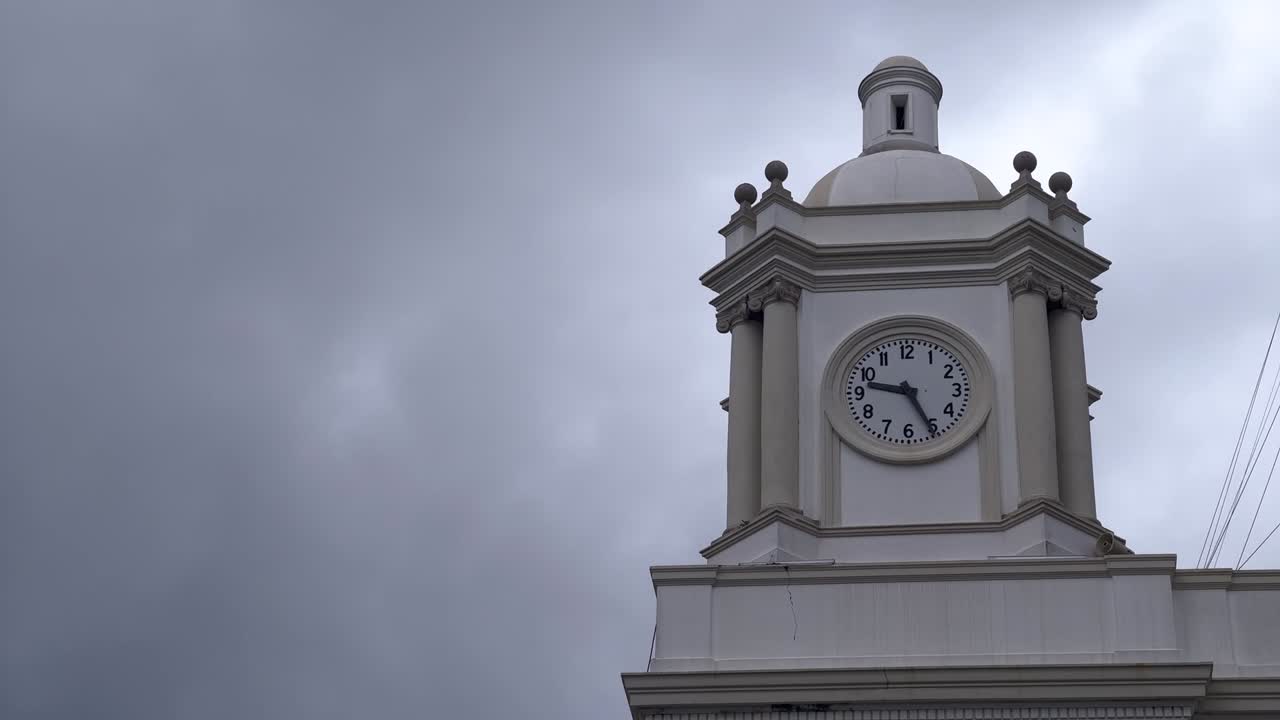Time lapse of town hall clock with sky clouds moving fast
