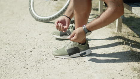 Close-up-shot-of-man-with-bionic-leg-tying-laces-on-sneakers