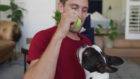 Caucasian-man-is-playing-with-his-dog-at-home