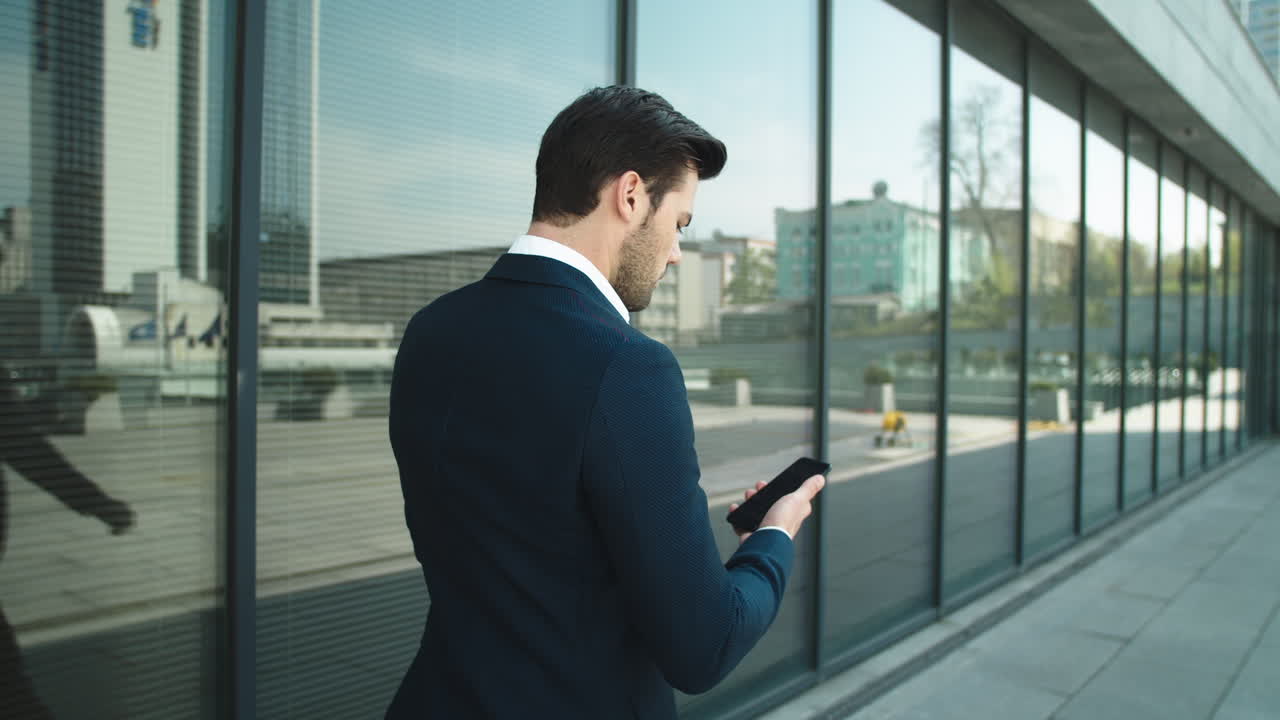 Confident man using smartphone outdoors