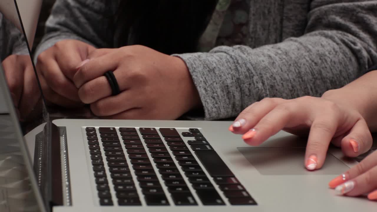 Close up of a student typing on her laptop.