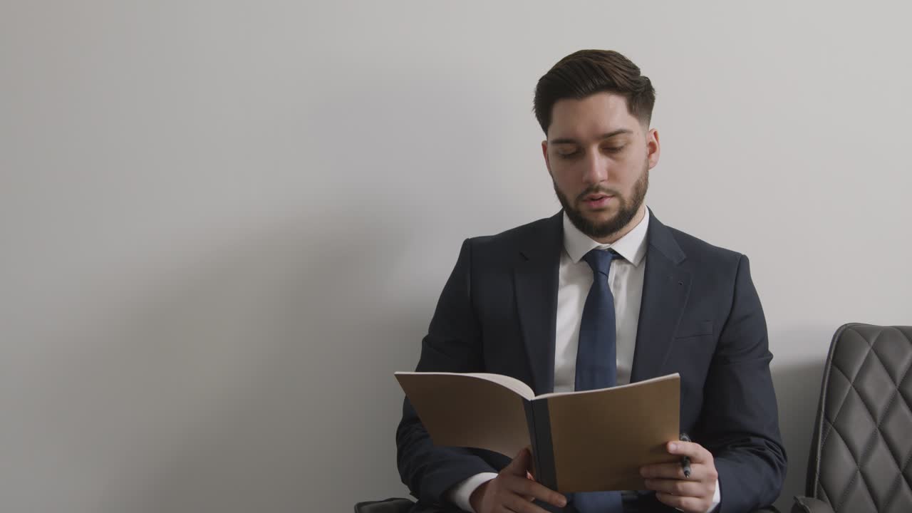candidato masculino con traje en la oficina revisando notas antes de la entrevista de trabajo 3