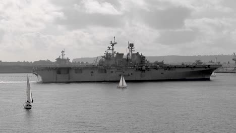 san diego warship next to a sailboat