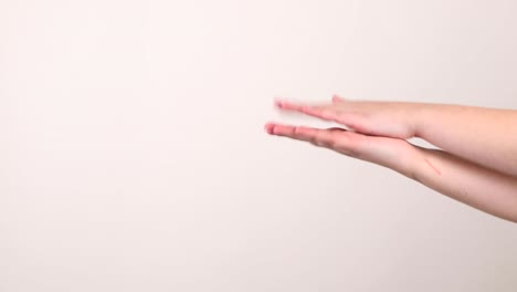 un par de manos aplaudiendo lateralmente en el lado derecho frente a un fondo blanco