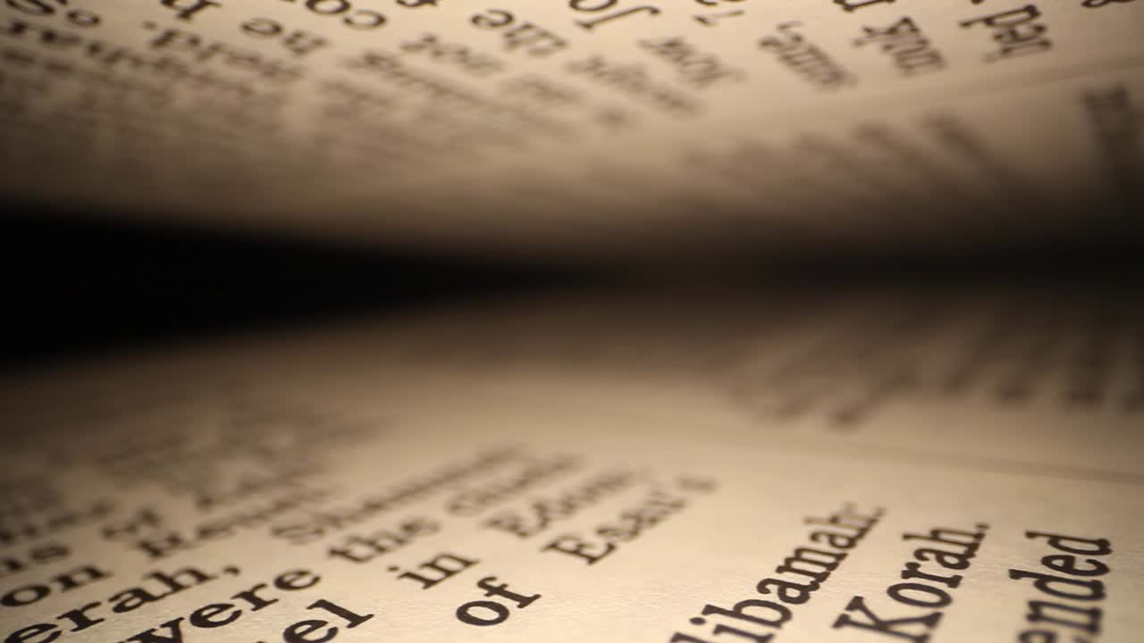 moving diagonally through a book left to right, pages on top - bottom of frame as it passes down to the end