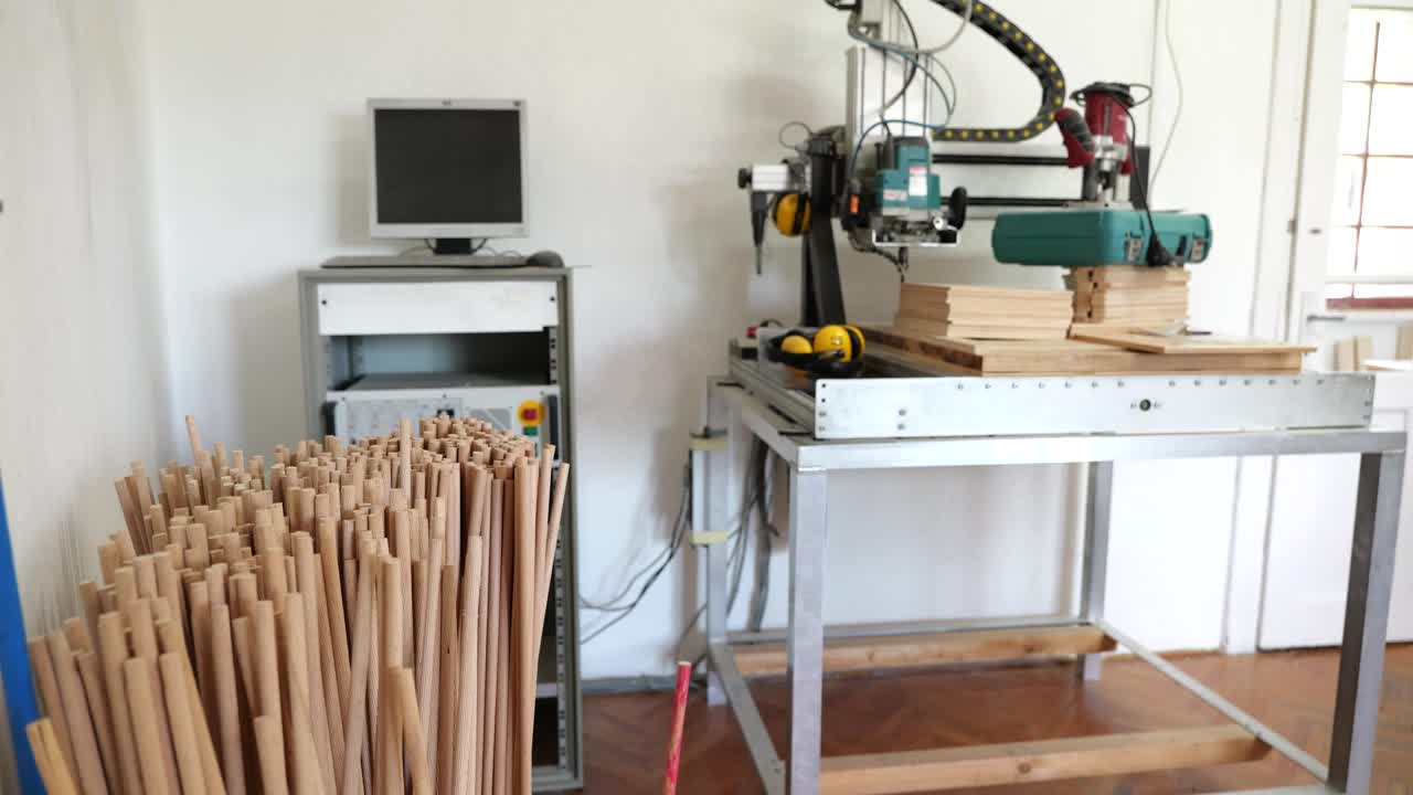 Container of dowels, computer connected to wood cutting machine in game factory
