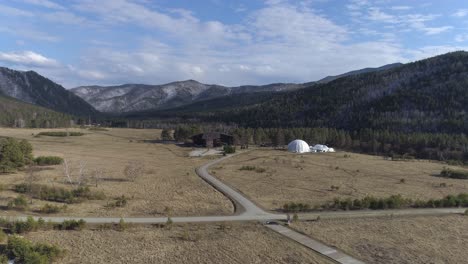 vista aérea de una casa y cúpula en un bosque rodeado de montañas