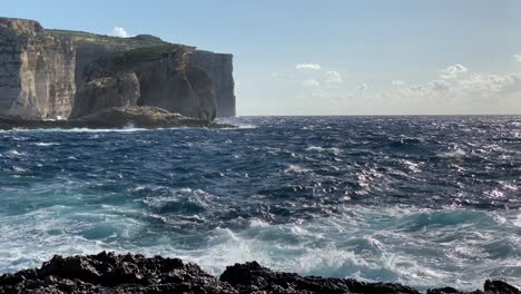 view over sunny blue restless sea towards fungus rock and dwejra bay, gozo malta