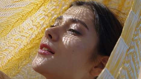 vertical portrait woman rest hammock in summer sunlight. beautiful girl posing