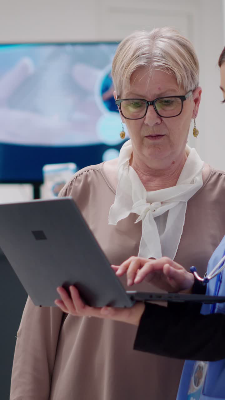 Senior patient and doctor looking at laptop