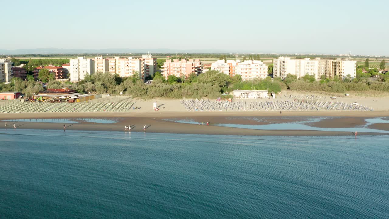 toma aérea de playa de arena con sombrillas y miradores
