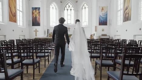 couple walking down church aisle at wedding ceremony