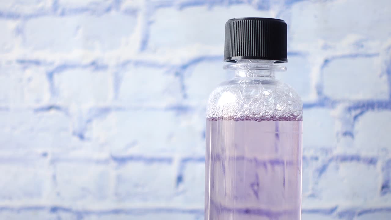 파란 벽돌 바탕에 보라색 액체 병