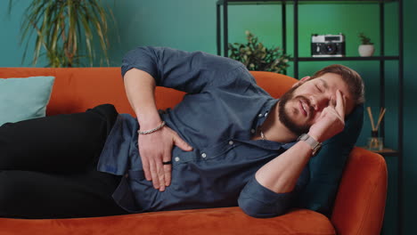 a man lying on a couch in pain