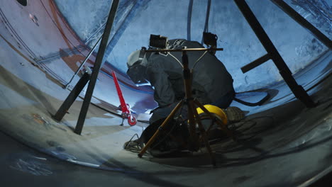 welder working on a large metal tank