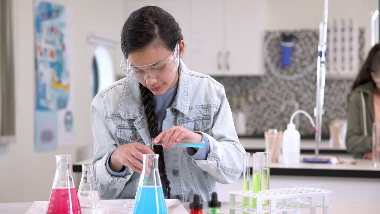 Girl conducting science experiment in school lab, focusing on test tubes