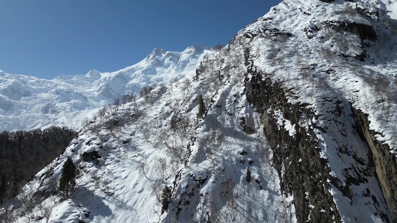 Drone flight over the rugged, snow-covered terrain of Fairy Meadows in Pakistan's Hunza Valley, capturing the extreme Himalayan environment