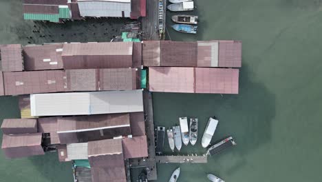 aerial flyover: bird's eye view of boats moored at chew jetty malaysia