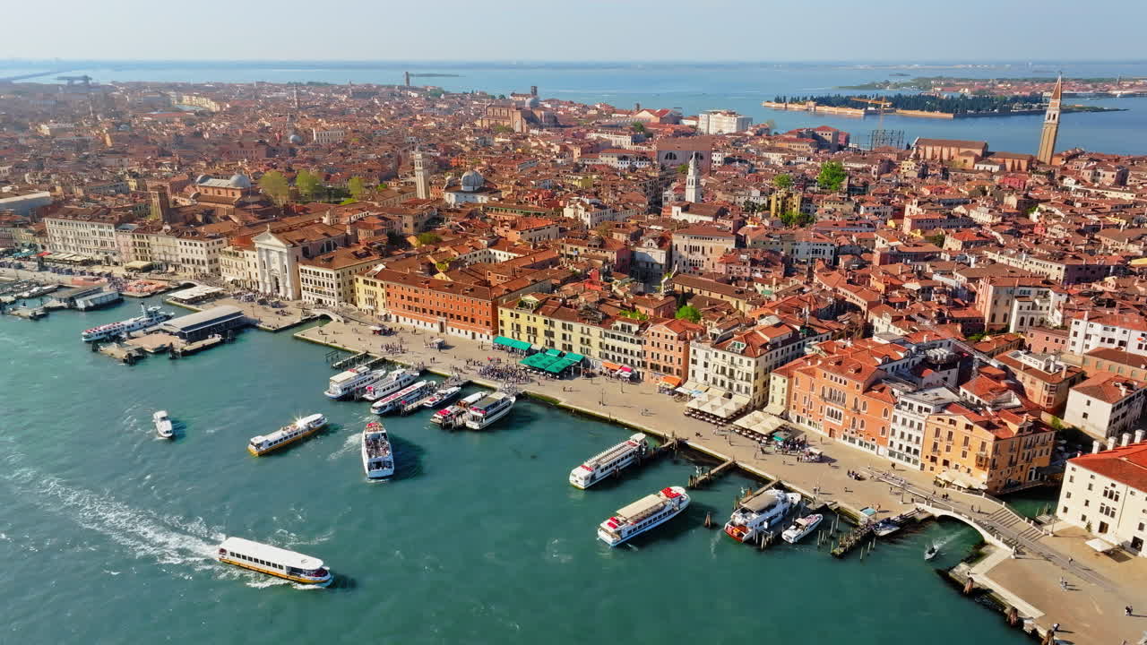 Aerial drone view of boats moving through Venice, Italy on a sunny day