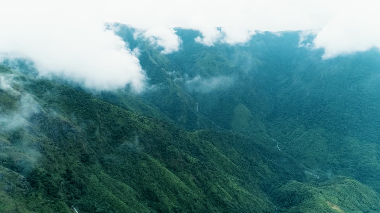 espectacular vista panorámica con laderas verdes de las montañas cubiertas por grandes nubes, tiro aéreo