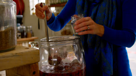 Mid-section-of-woman-taking-pickled-vegetable-in-container-4k