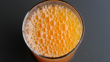 orange juice in a glass with bubbles