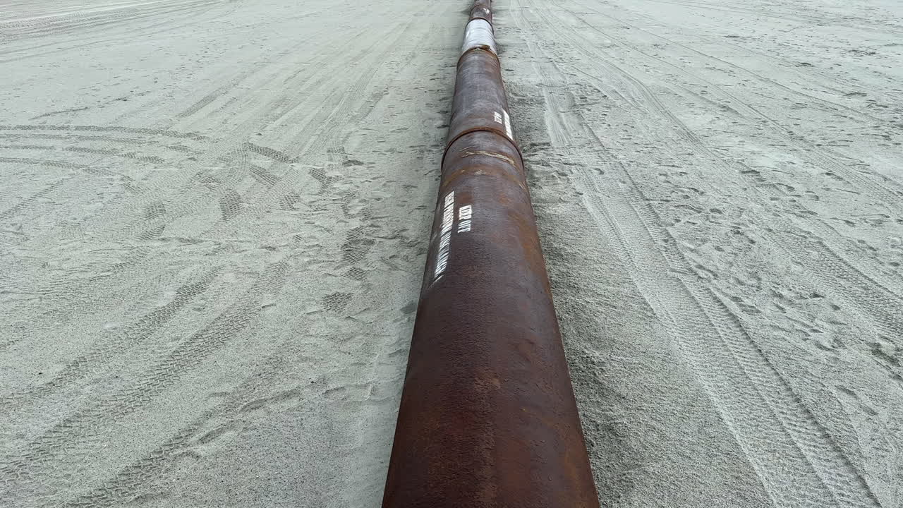 Pipe pumping sand from ocean during beach replenishment project