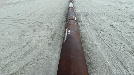 pipe pumping sand from ocean during beach replenishment project