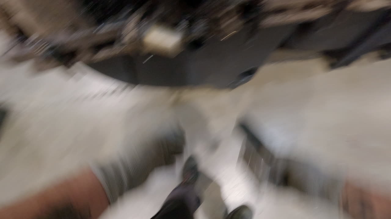 рабочий достает большой ржавый металлический штырь, чтобы отпереть и открыть бак для кражи ротоформовки, вид на промышленный процесс от первого лица.