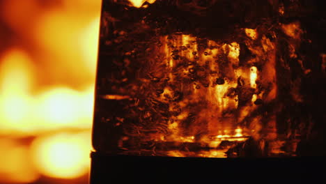 boiling water in a clear glassware on a background of open fire in a fireplace