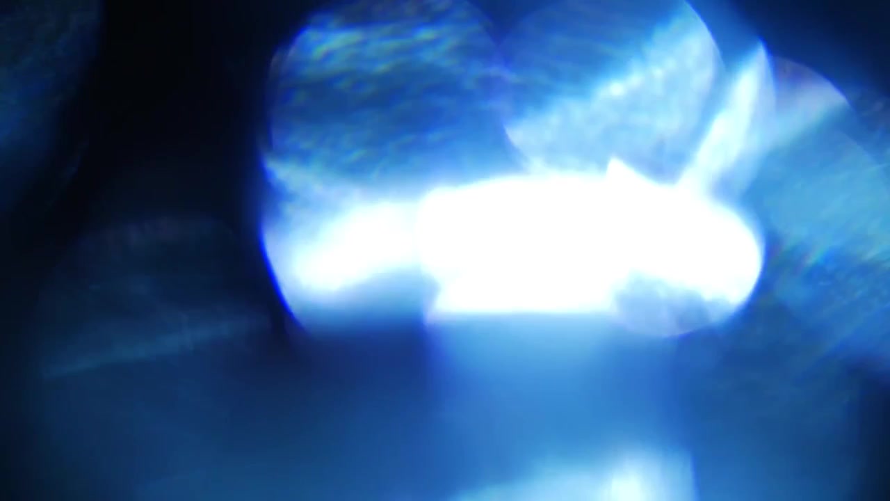 Perdite di luce blu astratte e bagliori dell'obiettivo su sfondo nero