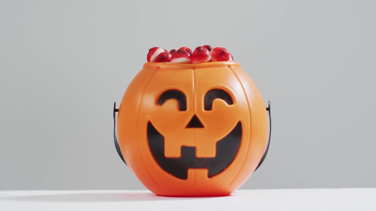 무서운 할로윈 호박 인쇄 버 ⁇ 은 회색 배경에 사탕으로 가득 차 있습니다