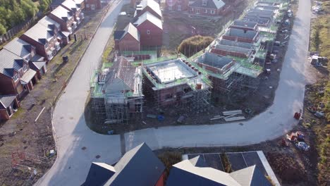 Aerial-view-above-suburban-townhouse-framework-on-development-construction-site-zooming-in