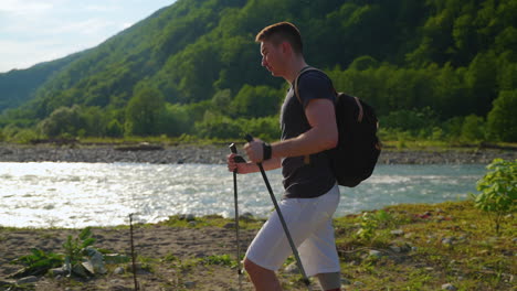 man hiking in mountains with hiking poles and prosthetic leg