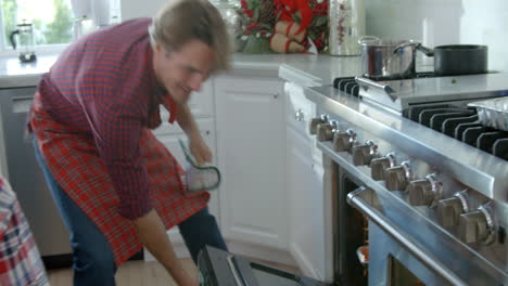 slow motion shot as dad takes christmas turkey out of oven