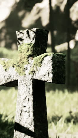 una cruz de piedra en un cementerio del bosque