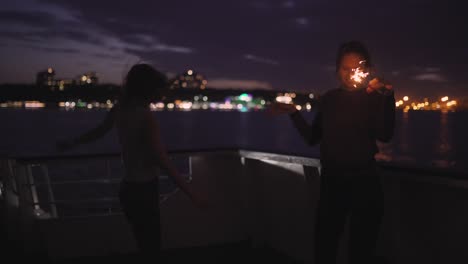 silhouette of two beautiful young women dancing on ship deck at night. girlfriends on the boat