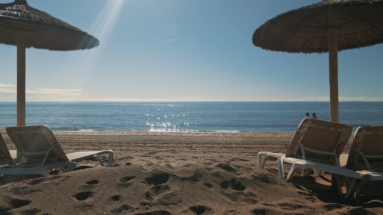sombrillas de playa con gente caminando por la costa