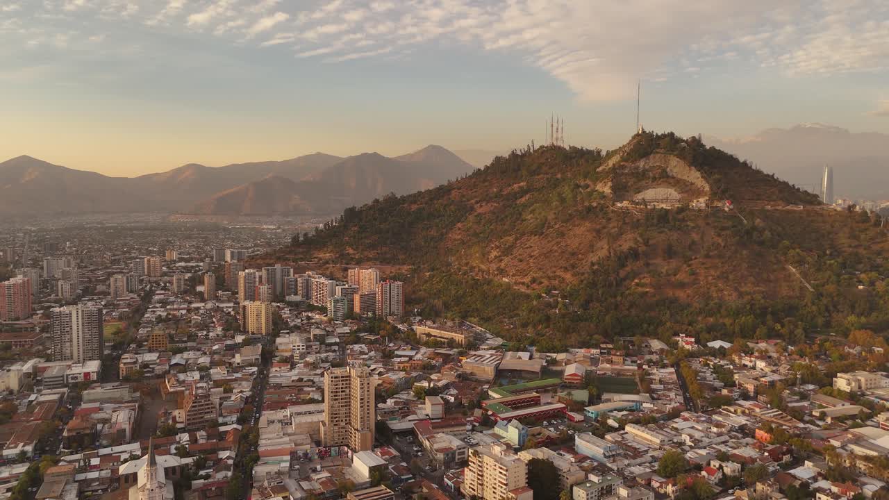 Vista aerea del paesaggio urbano del Cile e dell'ampio Parque Metropolitano durante un tramonto vibrante. Filmato in straordinaria risoluzione 4K a 60fps per immagini fluide e dettagliate